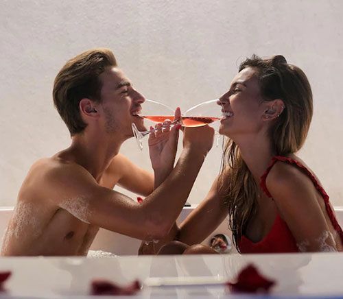 Pareja tomando champaña en un jacuzzi